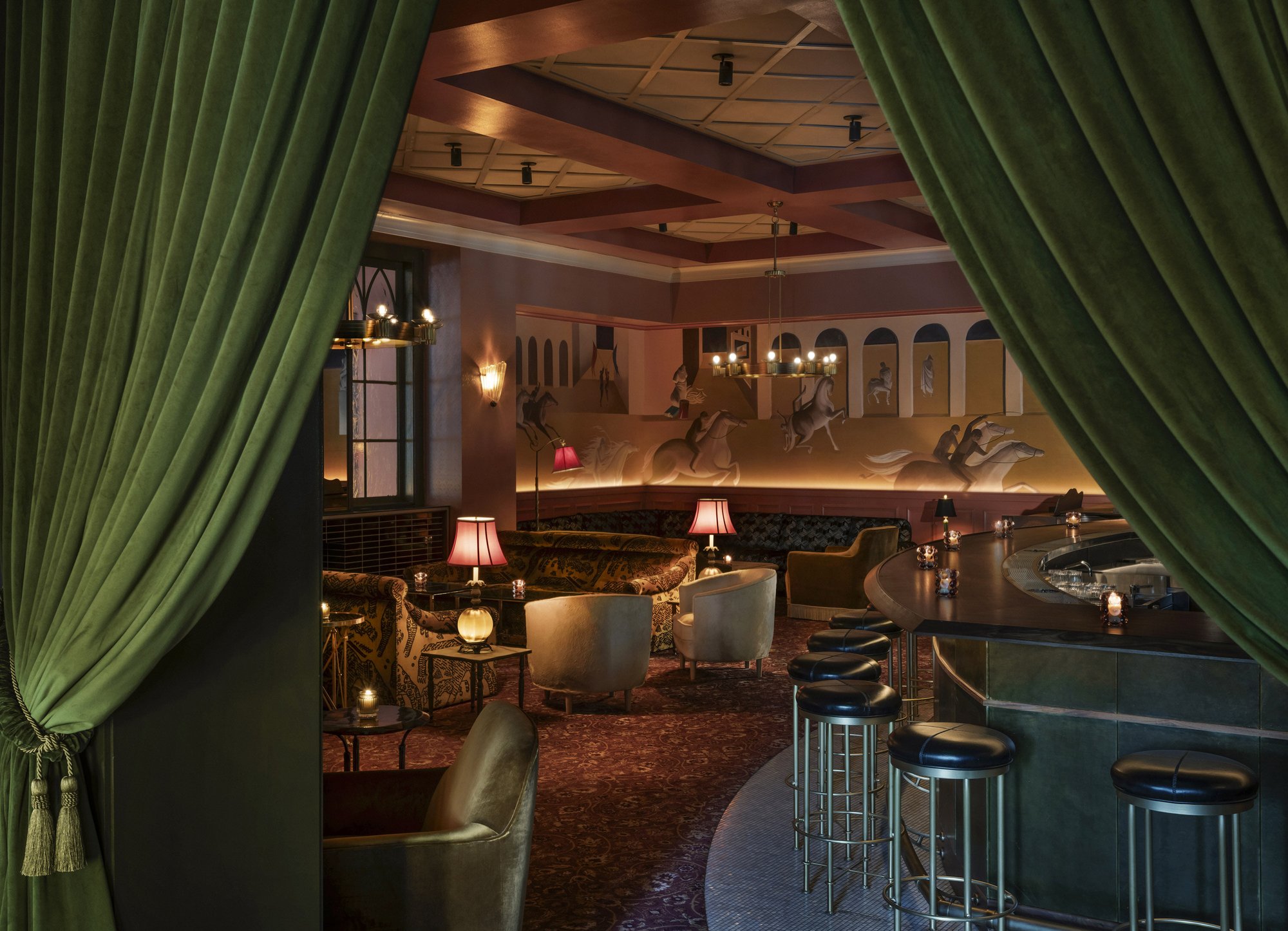 The Il Premio bar seen through green velvet curtains, with stools along the counter