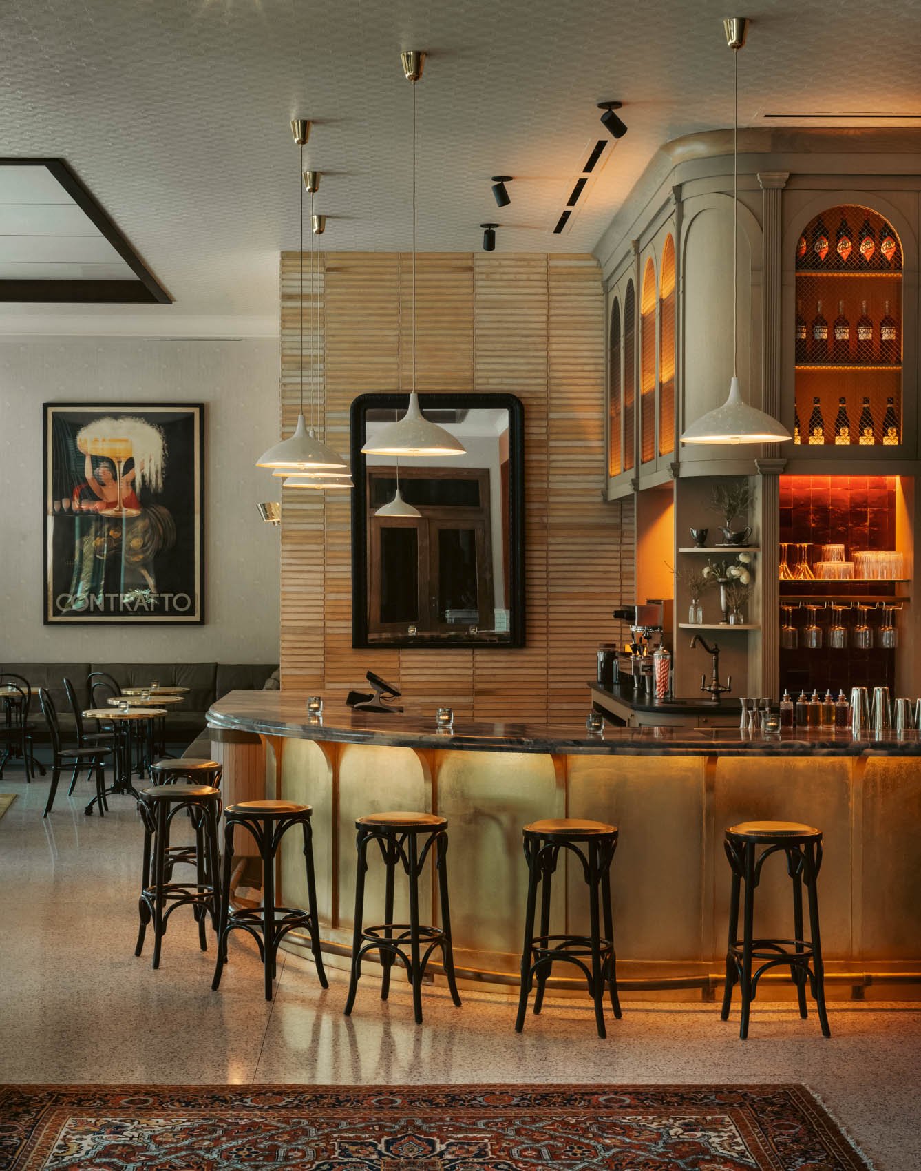 The brass-fronted bar at Bar Premio with bentwood stools and pendant lights