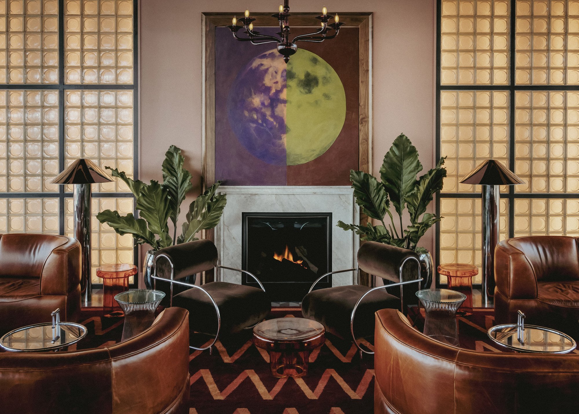 Moonlight’s lounge with leather armchairs gathered around the fireplace beneath a moon painting