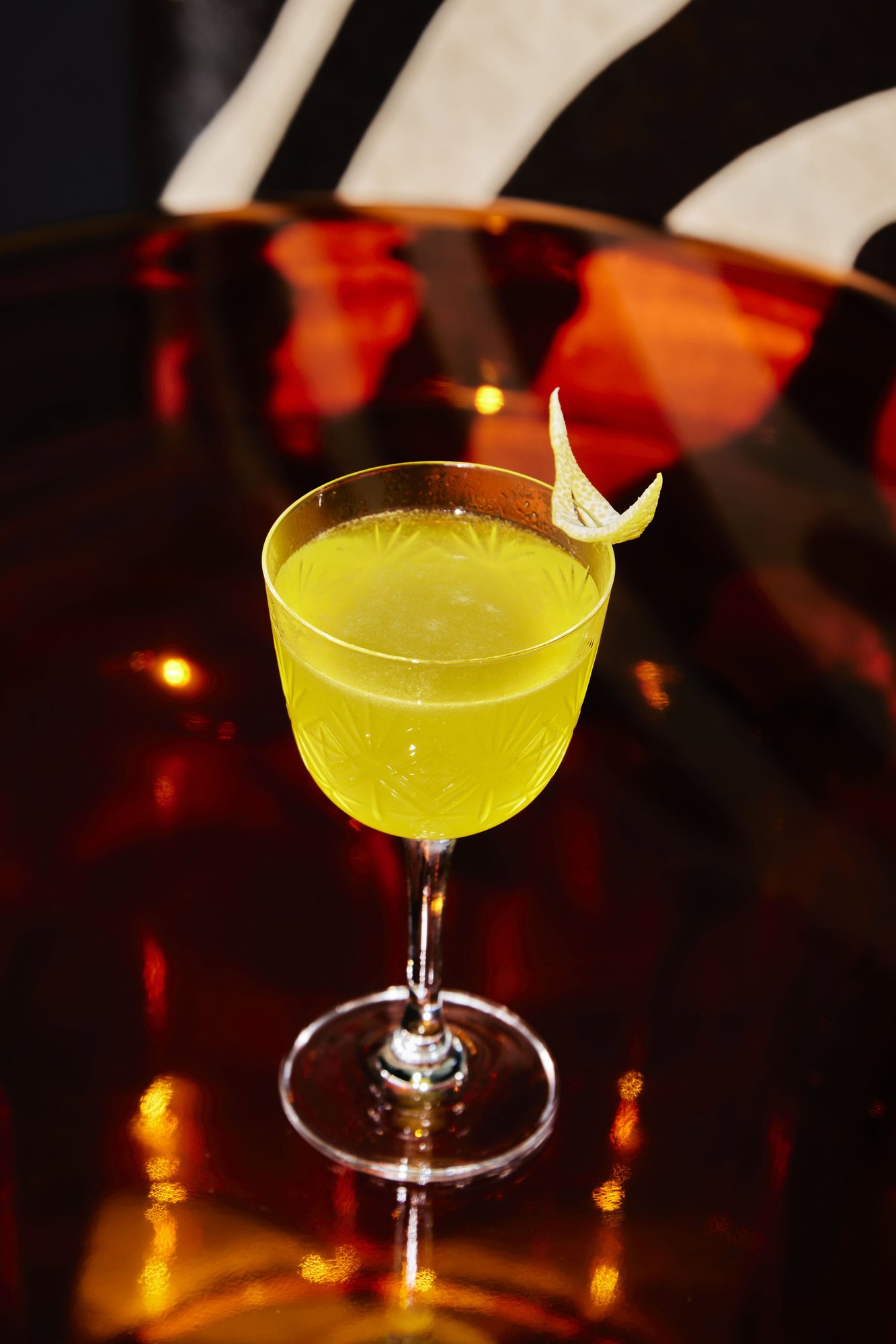 A chartreuse cocktail with a citrus twist on the bar at Moonlight
